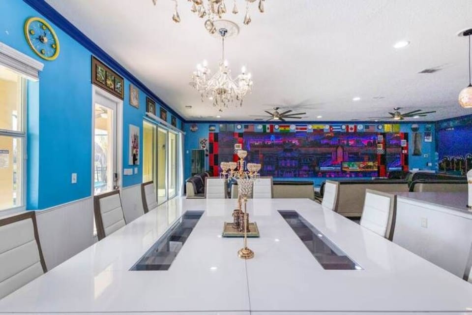 Elegant dining room with a vibrant mural and chandeliers, perfect for hosting large gatherings.