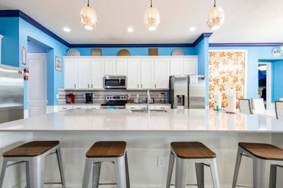 Bright and modern kitchen with ample seating and high-end appliances, perfect for entertaining large groups.