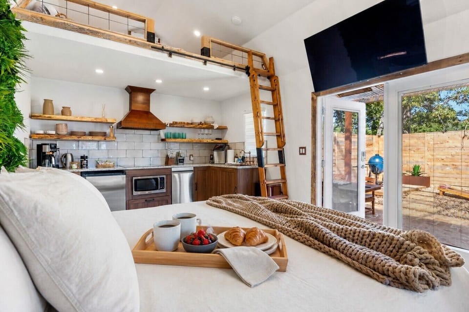 King bed, full kitchen, loft, and Smart TV in one bright open cabin, with breakfast ready for two.