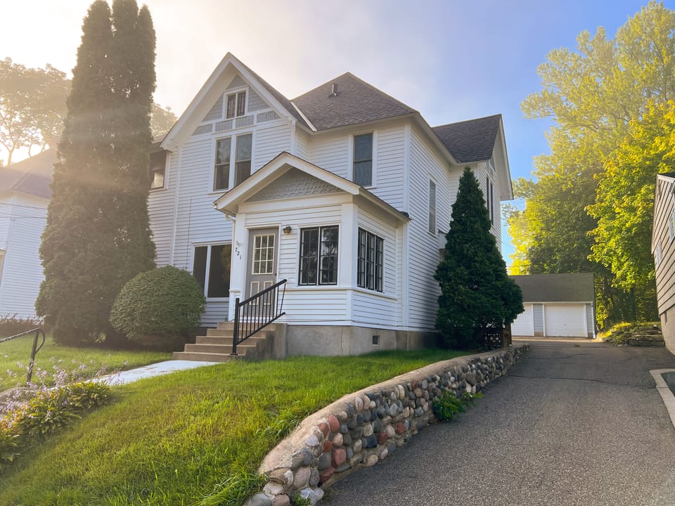 Front of house with driveway to back and garage