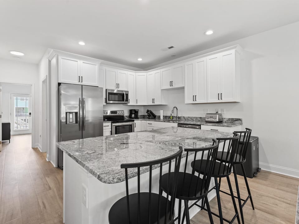 Your gourmet kitchen awaits with granite countertops, stainless steel appliances, and a spacious island perfect for morning coffee or evening meals together.