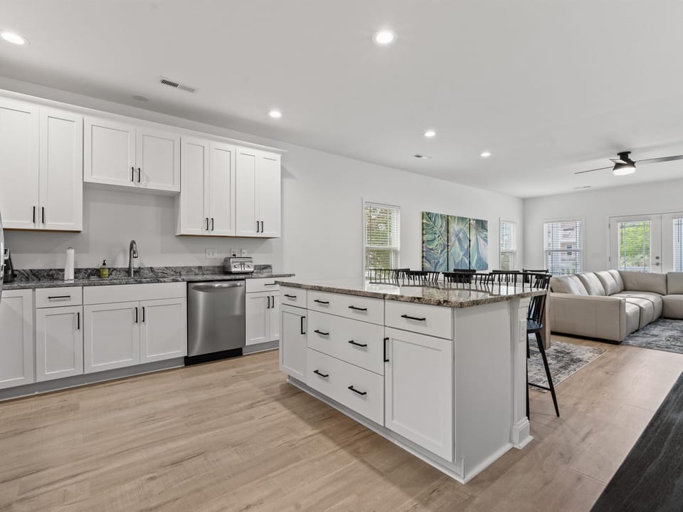 Step into your spacious modern kitchen with gleaming granite countertops, stainless steel appliances, and a breakfast bar perfect for morning coffee.