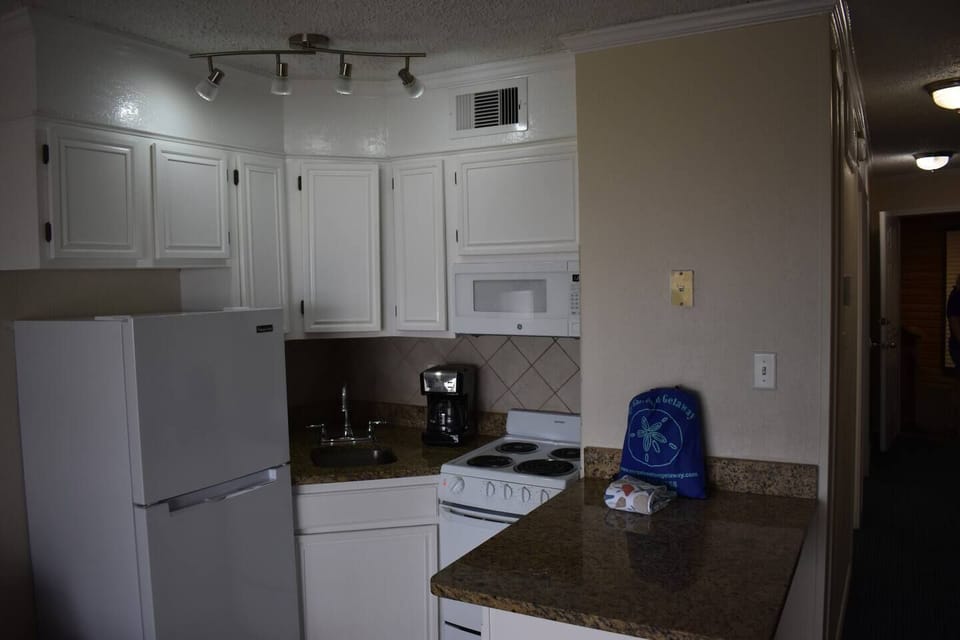 Kitchen with range, microwave, refrigerator, and countertop appliances