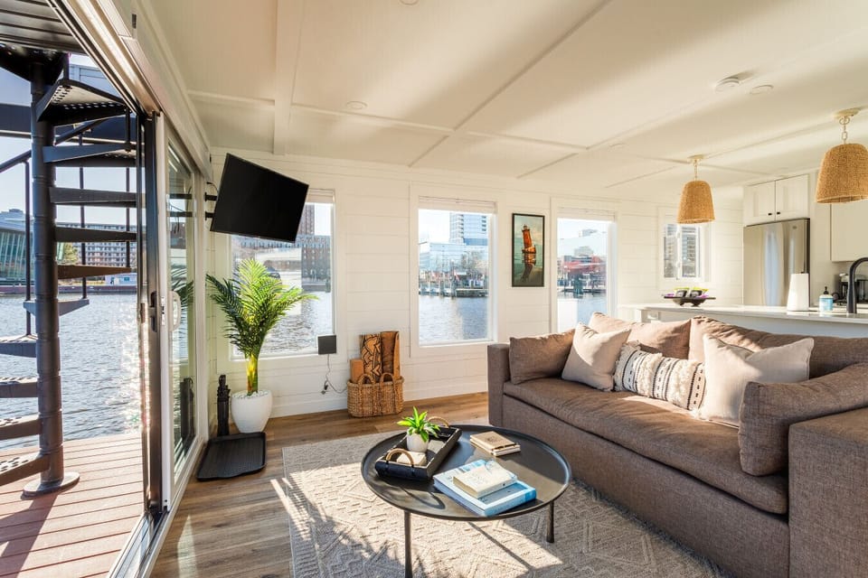 Cozy interior view of the living area with spiral staircase access to the rooftop, Roku Smart TV, and Sonos Bluetooth speaker setup.