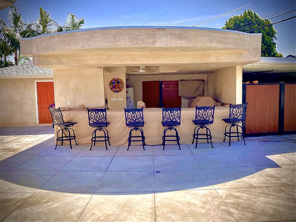 Outdoor Kitchen. 65” tv, grill, wok, 2 burner, sink, large fridge, pantry.