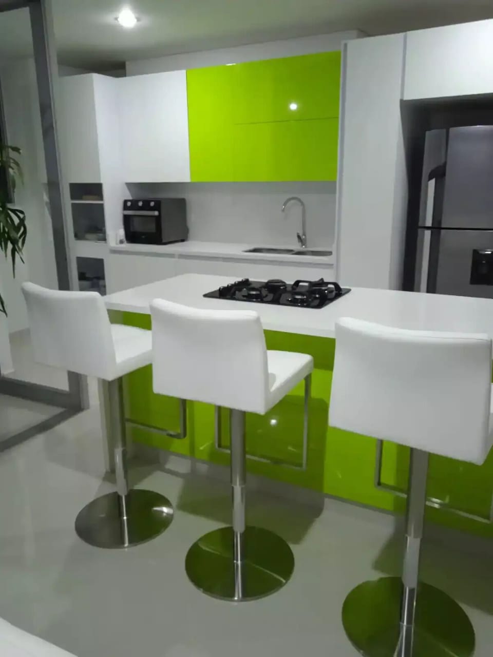 cocina abierta con isla para 3 puestos con sillas en cuero y de altura graduable