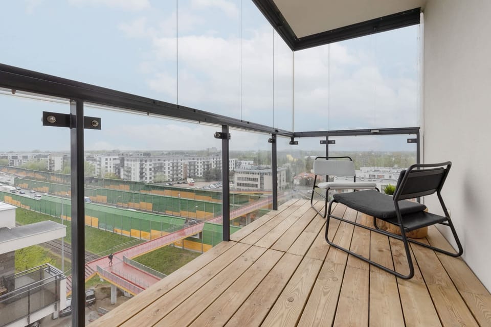 A spacious balcony with a seating area overlooking a cityscape, providing a perfect spot to relax.