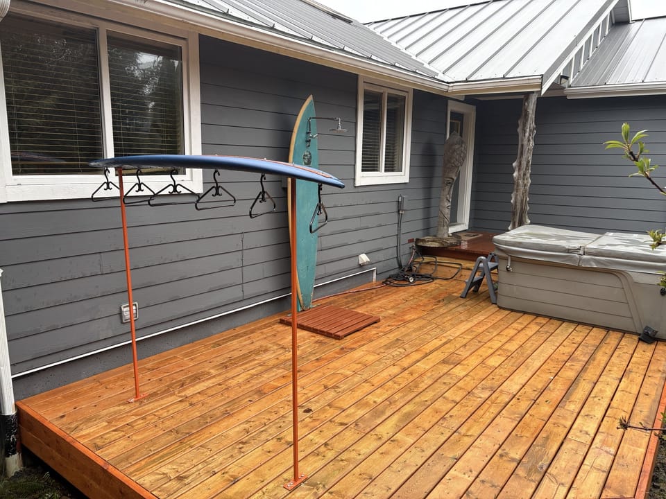 Front deck with a hot tub and outdoor shower