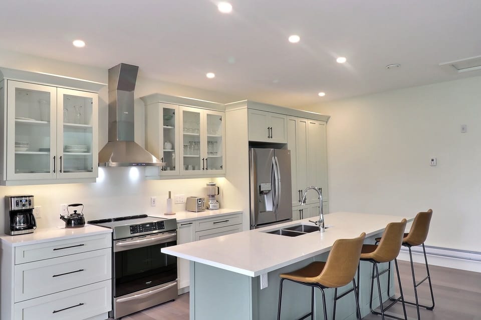 Spry 4 kitchen with induction range, 36" frig with pantry cabinet storage and Island seating all quartz countertops