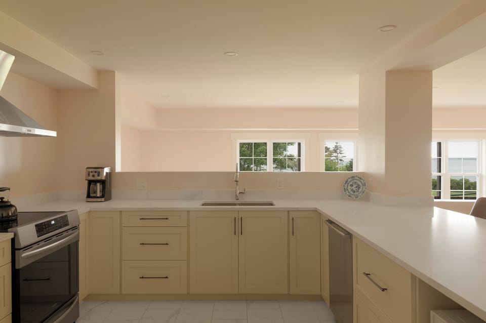 Spry 5 kitchen view looking out to the water 100' away. Wide quartz slab peninsula with bar stool seating.