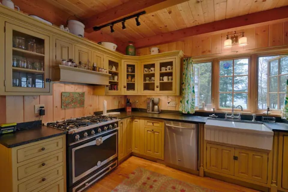 Modern country kitchen with six-burner stover, farmhouse sink and dishwasher.