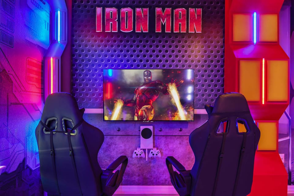 Immersive Iron Man gaming setup with LED lights, dual chairs, and console-ready TV