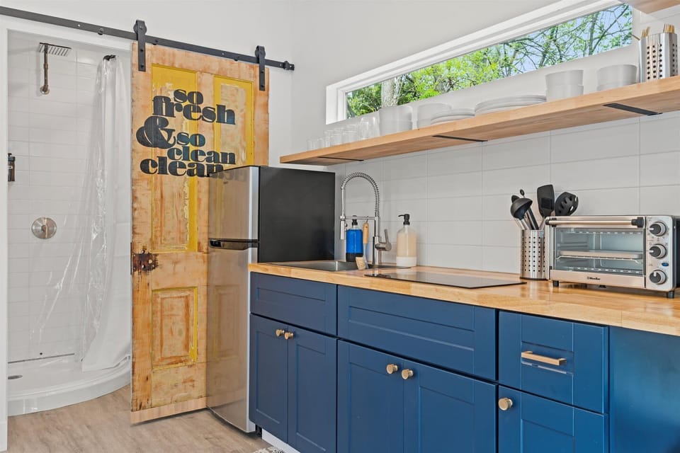 Kitchenette with refrigerator, electric cooktop, toaster oven, Keurig K-Cup coffee maker, and beautiful wooded views.