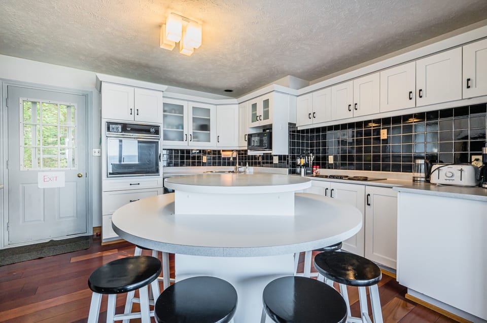 Enjoy drinks or dining at the large kitchen island with stools. The kitchen is fully equipped with modern appliances and utensils for you to use.