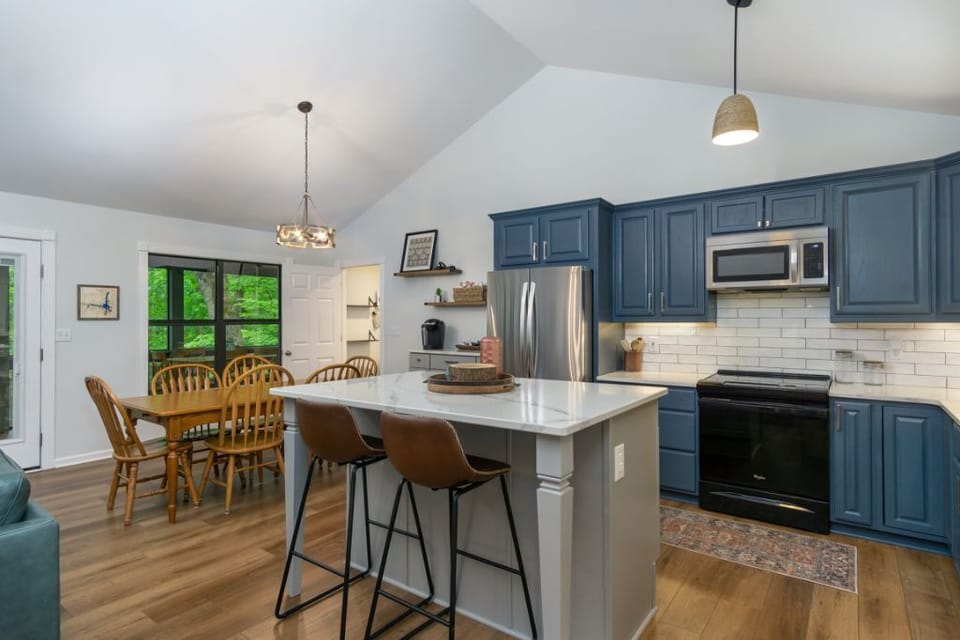Fully equipped kitchen with blue cabinets and updated back splash.