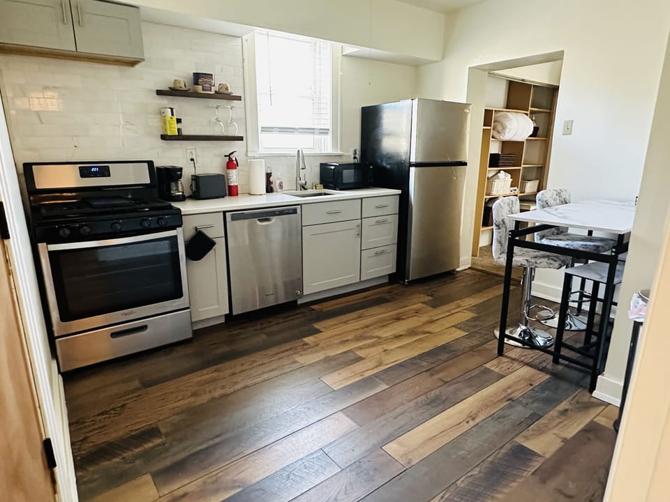 Fully equipped kitchen with a coffee pot, toaster, microwave, and dishwasher.