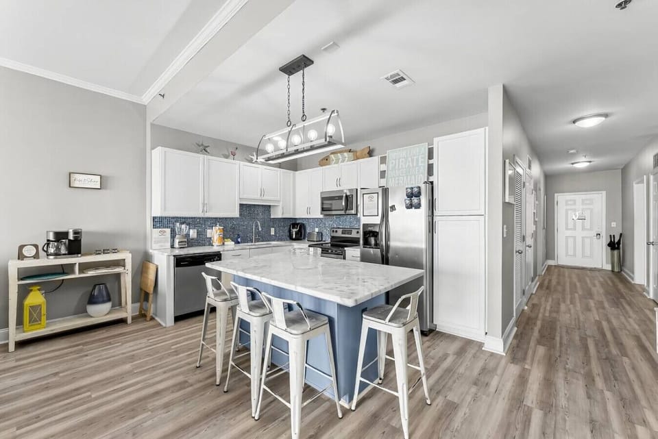 Fully stocked kitchen with island that has seating for 4 and hallway to front door