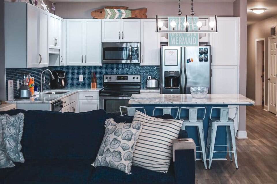 Fully stocked kitchen with island that has seating for 4 and hallway to front door