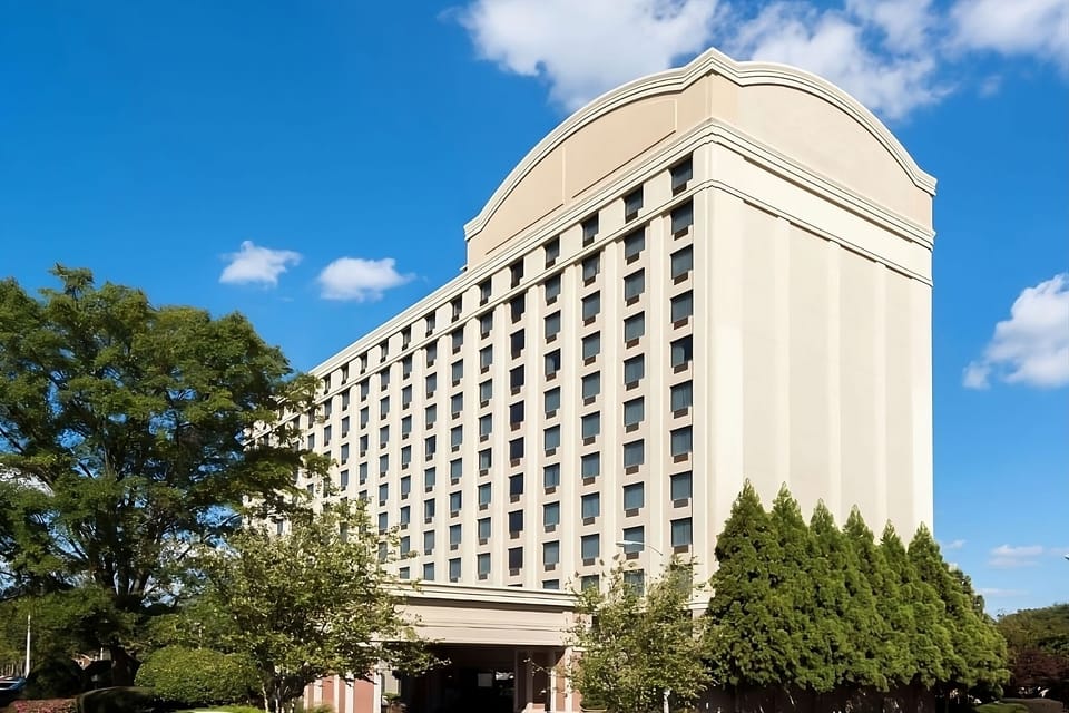 Picture sunny arrivals with landscaped grounds and clear signage.