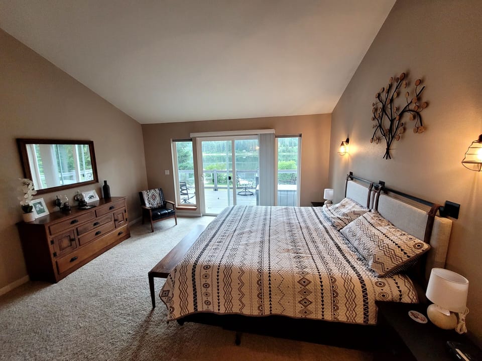 King size primary bedroom with unobstructed river views & walkout slider.