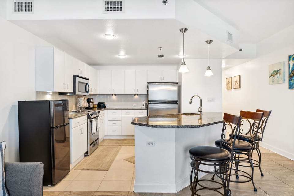 Modern kitchen with stainless steel appliances and a breakfast bar for casual dining.