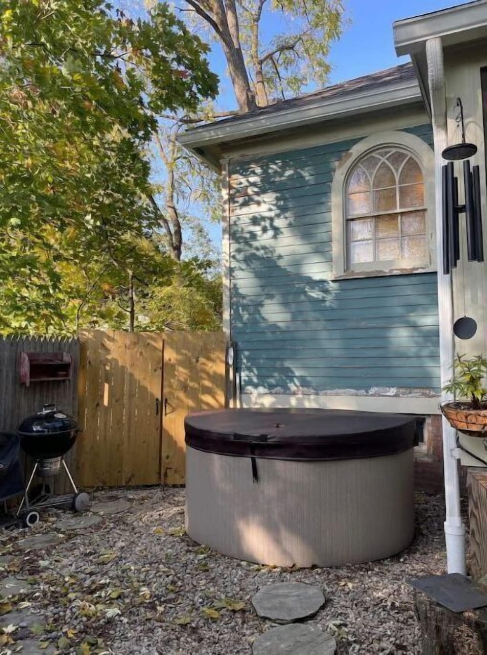 The hot tub is tucked into the side of the backyard out the sunroom steps