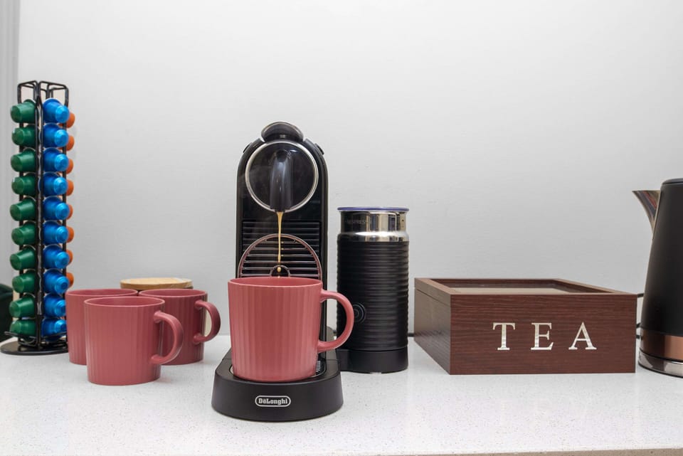Coffee machine with milk frothier and pods provided