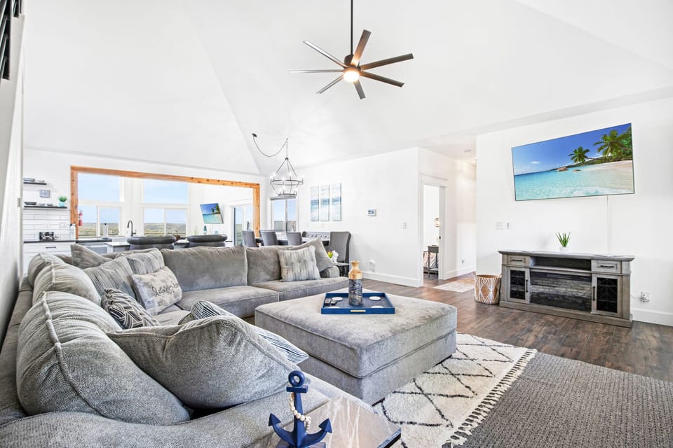 The front living area is complimented by a smart television and another sectional sofa for large groups to gather