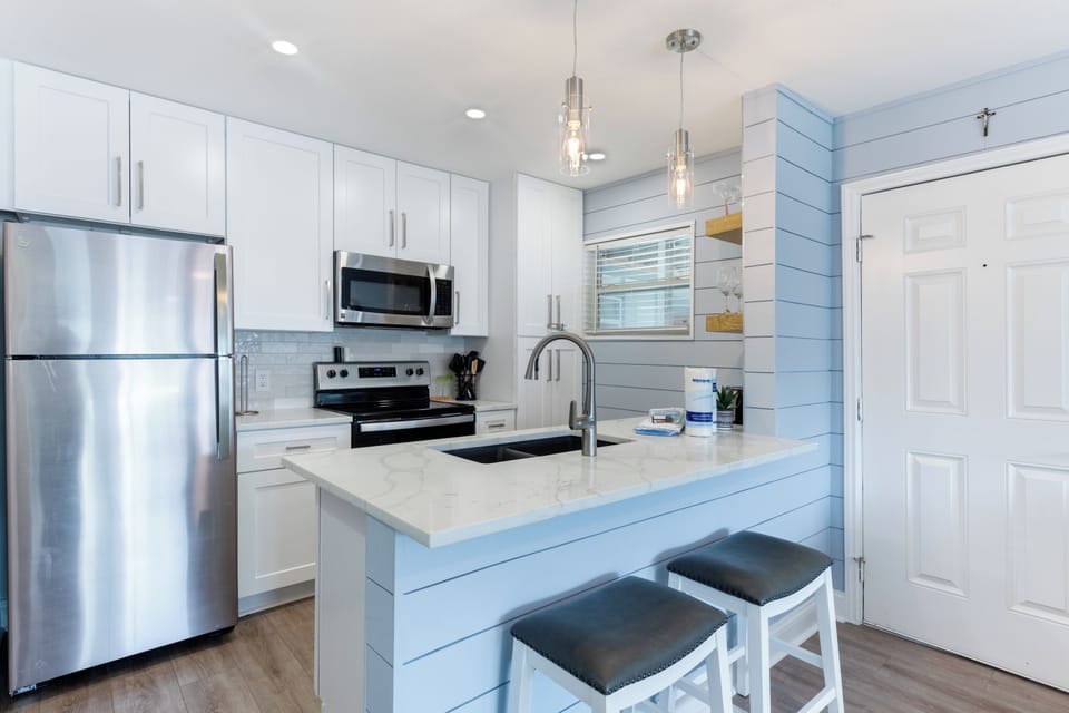 Your bright, modern kitchen features sleek white cabinets, marble countertops, and stainless steel appliances for effortless meal prep.