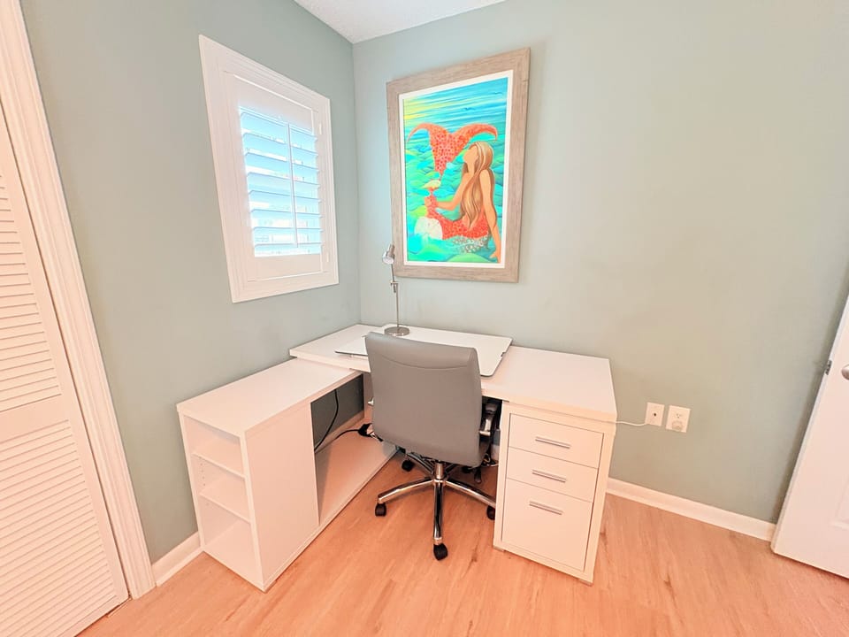 Your private workspace awaits with a comfortable desk setup and cheerful mermaid artwork to inspire your stay.