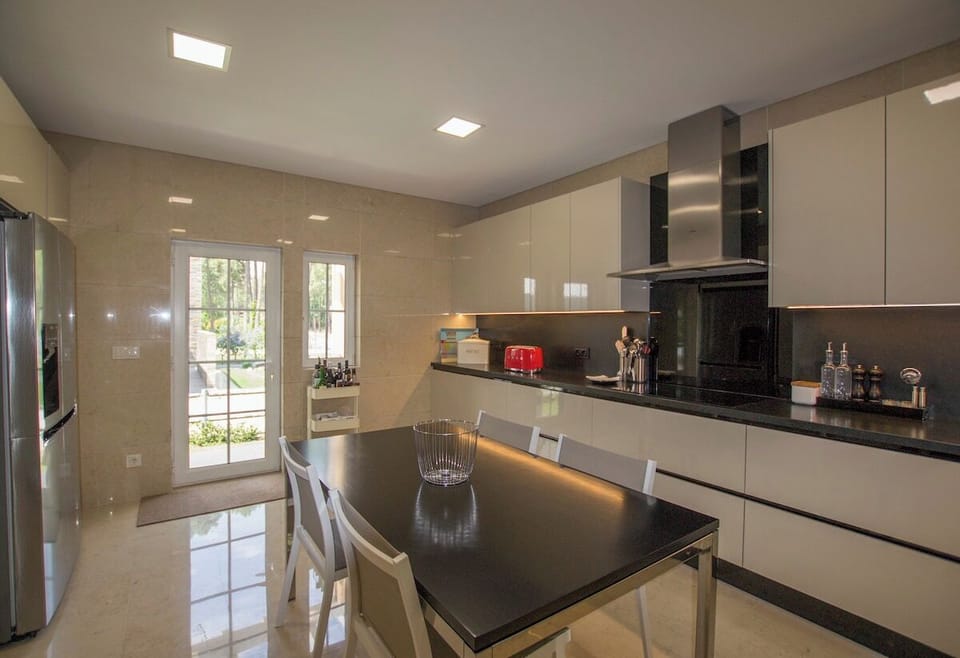 Modern kitchen with black granite countertops and cream cabinetry — Villa Buganvilia III, holiday villa in Herdade de Aroeira