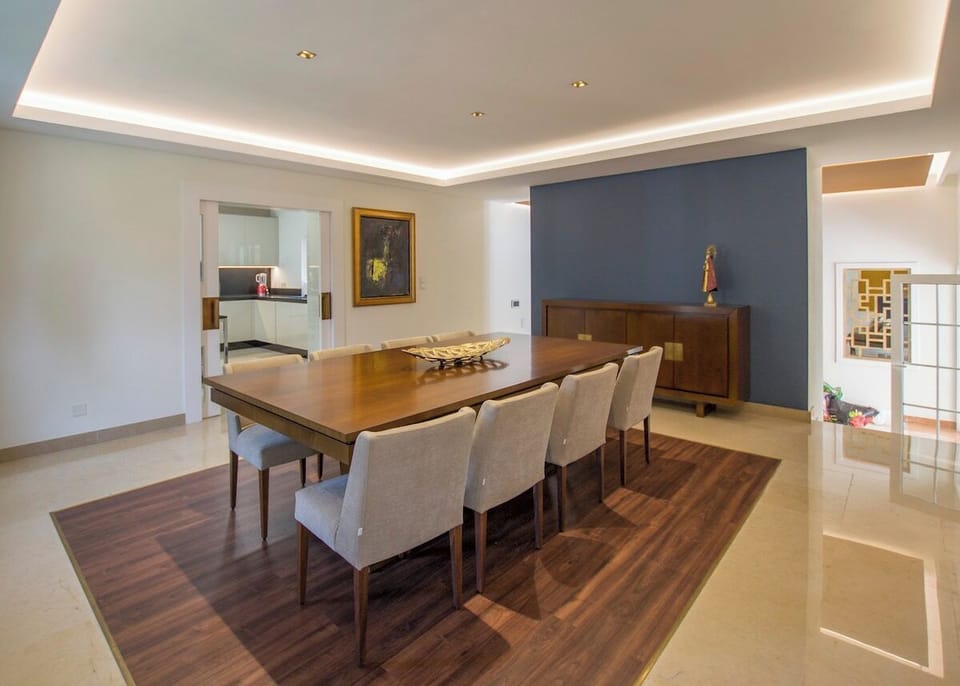 Elegant dining room with wooden table and upholstered chairs — Villa Buganvilia III, luxury holiday villa in Herdade de Aroeira