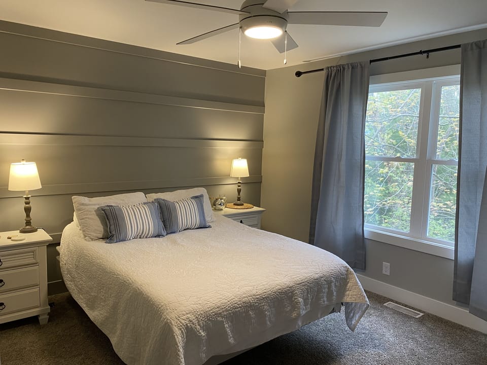 Primary bedroom upstairs with queen bed and TV