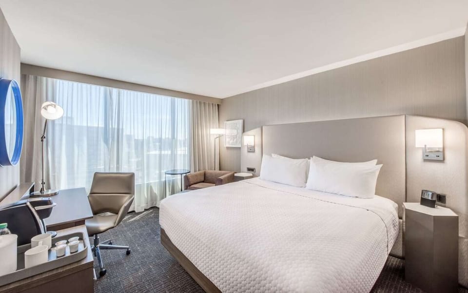 Linger longer in a serene bed framed by soft, modern lighting.