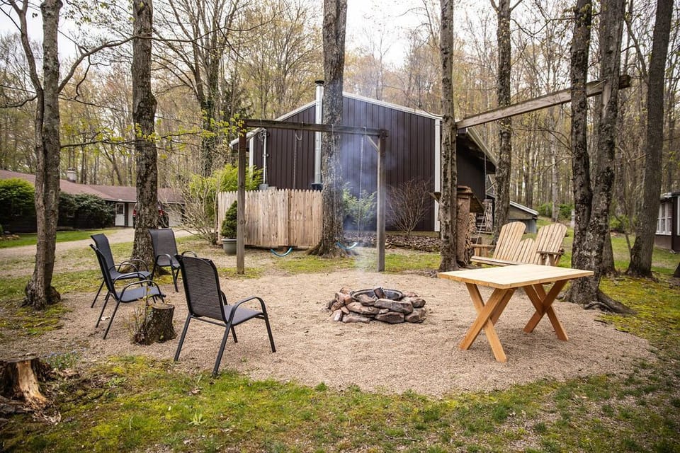 A cozy outdoor space with a firepit and chairs.