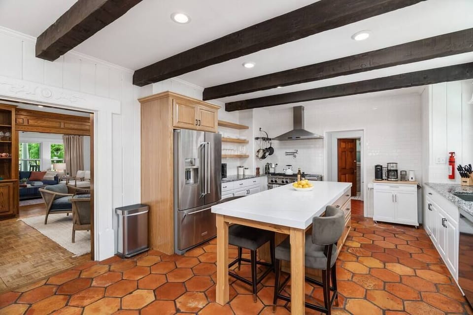 Experience culinary excellence in the gourmet kitchen, complete with sleek stainless steel appliances and a spacious island boasting comfy and classy counter stools. 