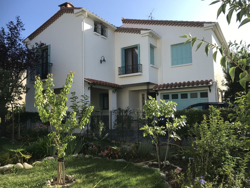 The newly painted house has a pool and gardens
