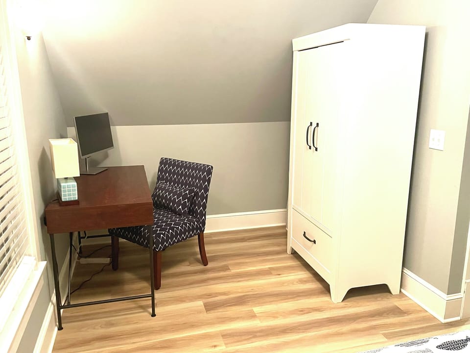 Workspace and wardrobe with hanging and drawer space in king bedroom.