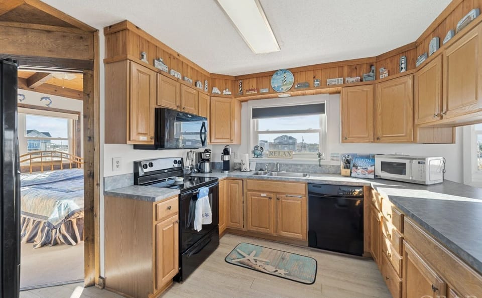 Full appointed Kitchen with dishes, two coffee makers, pots and pans. 
