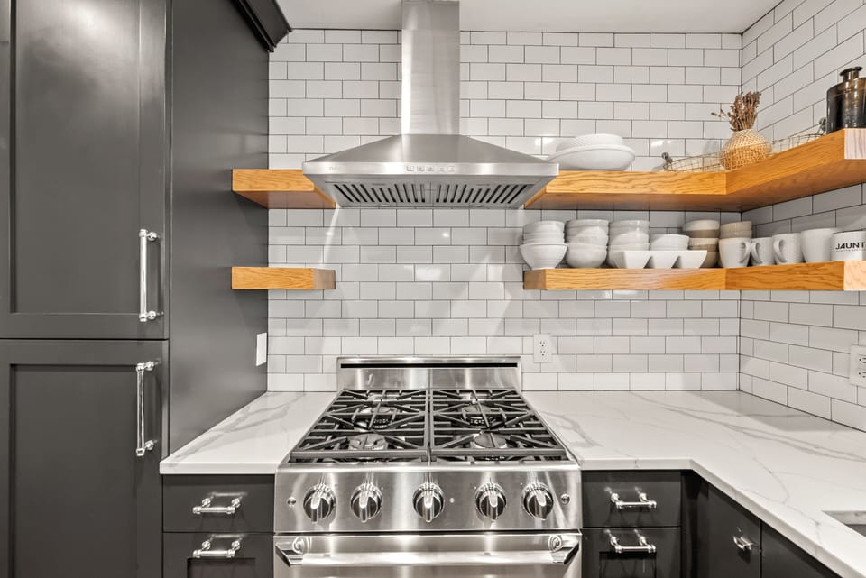 - Stainless steel gas stove with modern backsplash design  
- Open shelving stocked with essentials for easy access  
- Perfect for cooking meals during your Park City stay