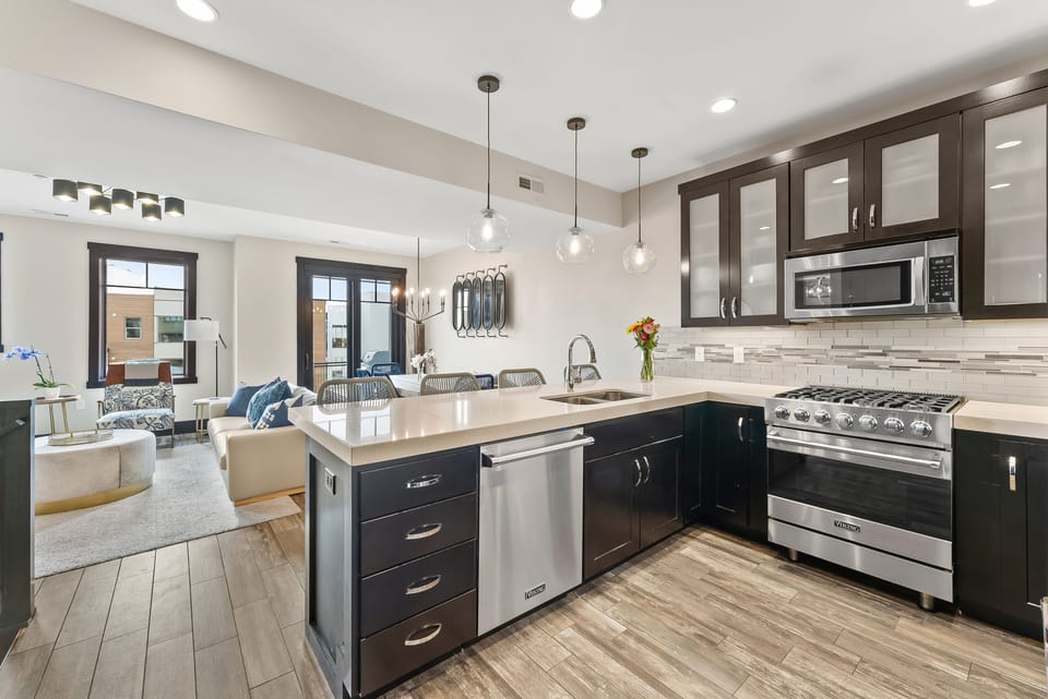 - Modern kitchen with gas range and open layout for cooking ease  
- Spacious island with sink and barstool seating for casual meals  
- Connected to living and dining area for family vacation comfort