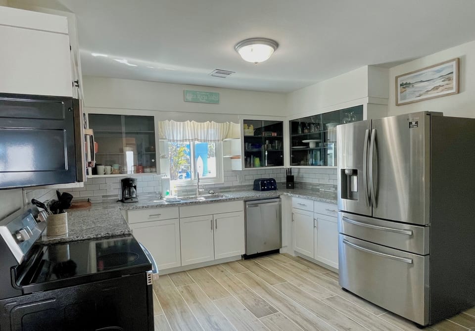 Kitchen with contrasting cabinets, stainless steel appliances, and island workspace