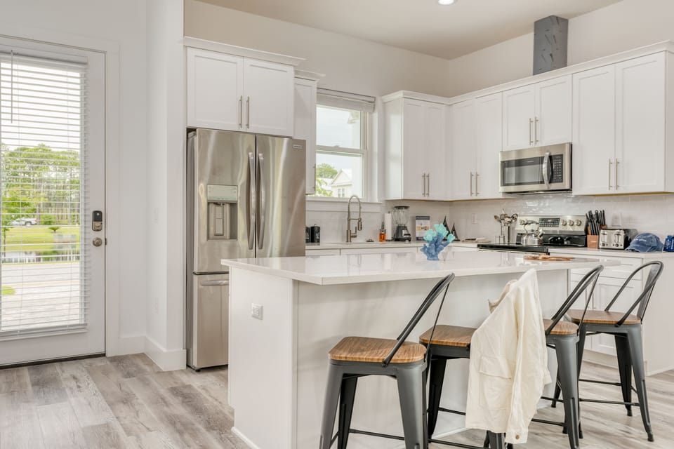 Fully-equipped kitchen with barstool seating at the counter.