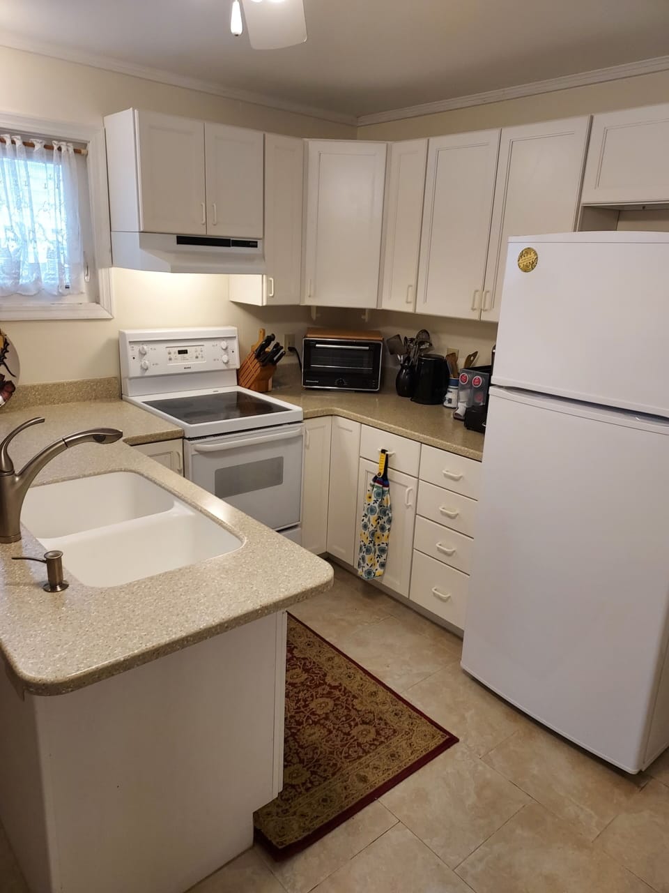 Fully equipped kitchen has an oven, stove, toaster oven, microwave, and Keurig.