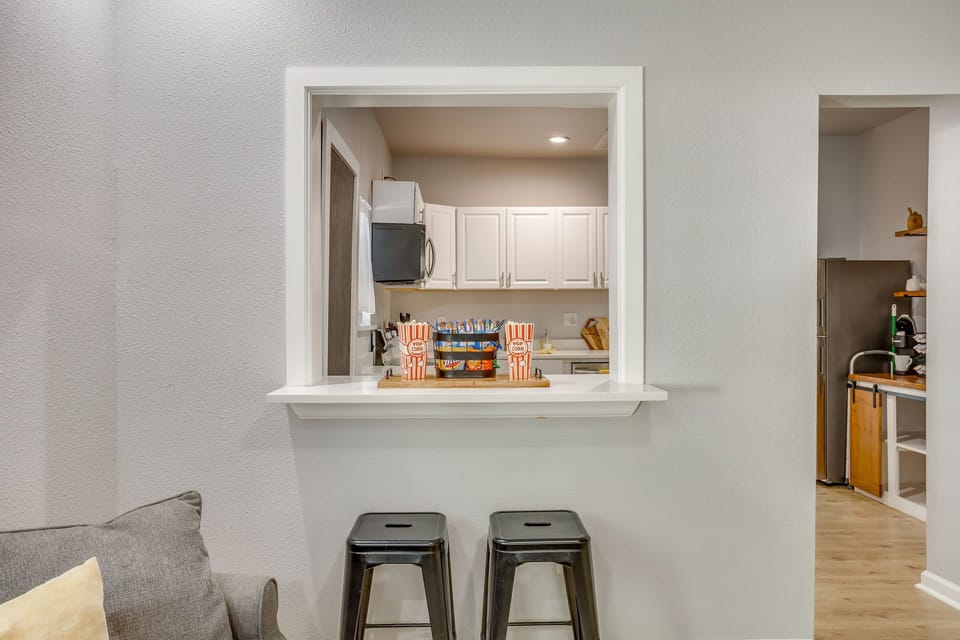 Open kitchen pass-through with bar seating — perfect for casual meals, morning coffee, or keeping the conversation going while someone cooks.