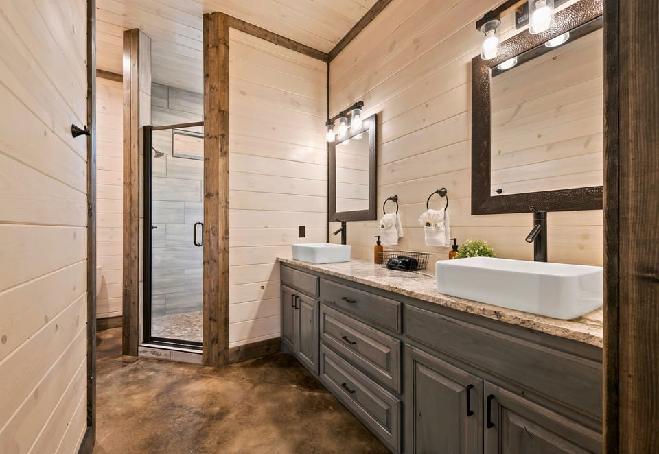 A well-designed bathroom featuring a double vanity, stylish lighting, and a glass-enclosed shower creates a harmonious blend of elegance and functionality.