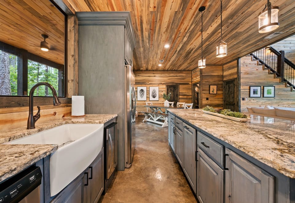 Experience culinary delights with a fully equipped kitchen featuring a charming farmhouse sink, elegant granite countertops, and modern cabinetry.