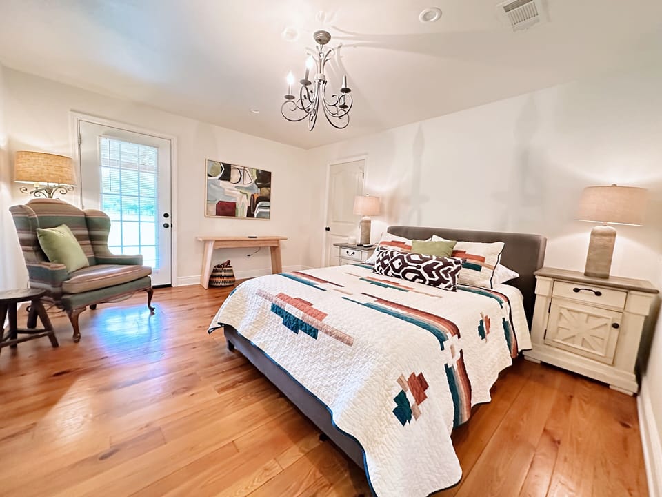 Primary queen-sized bed, with private en suite and access to back porch.