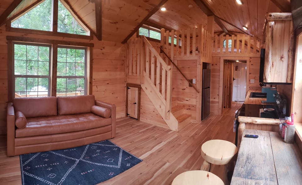 Kitchen/living/dining area of Tiny Toledo. Stairs lead to a loft with a king bed