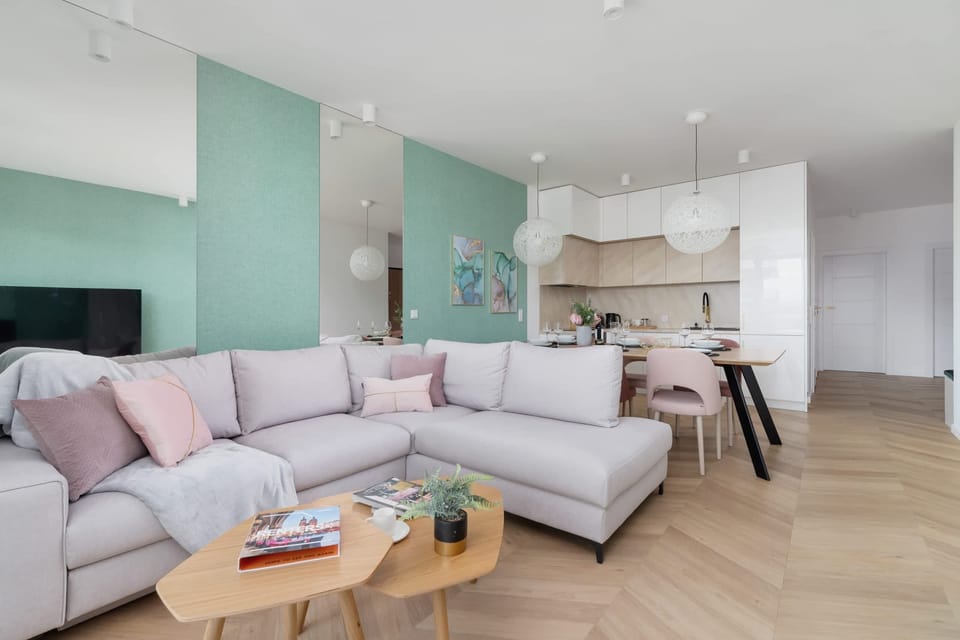 Living room with corner sofa bed, TV and dining area with fully equipped kitchenette.